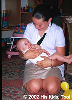 His Kids, Too! Volunteer, Lydia enjoys giving this baby some special attention