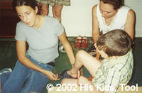 His Kids, Too! Volunteer, Lauren H. helps find sandals to fit orphans