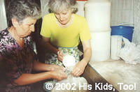 Church members, Leza and Zenya help fill bags of flour