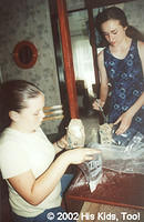 Volunteers Lena C. and Lydia F. fill bags with salt