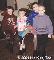 Four children display their new shoes and new clothes.