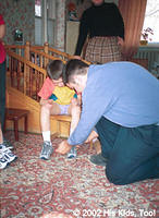 Dallas works on fitting shoes on children.